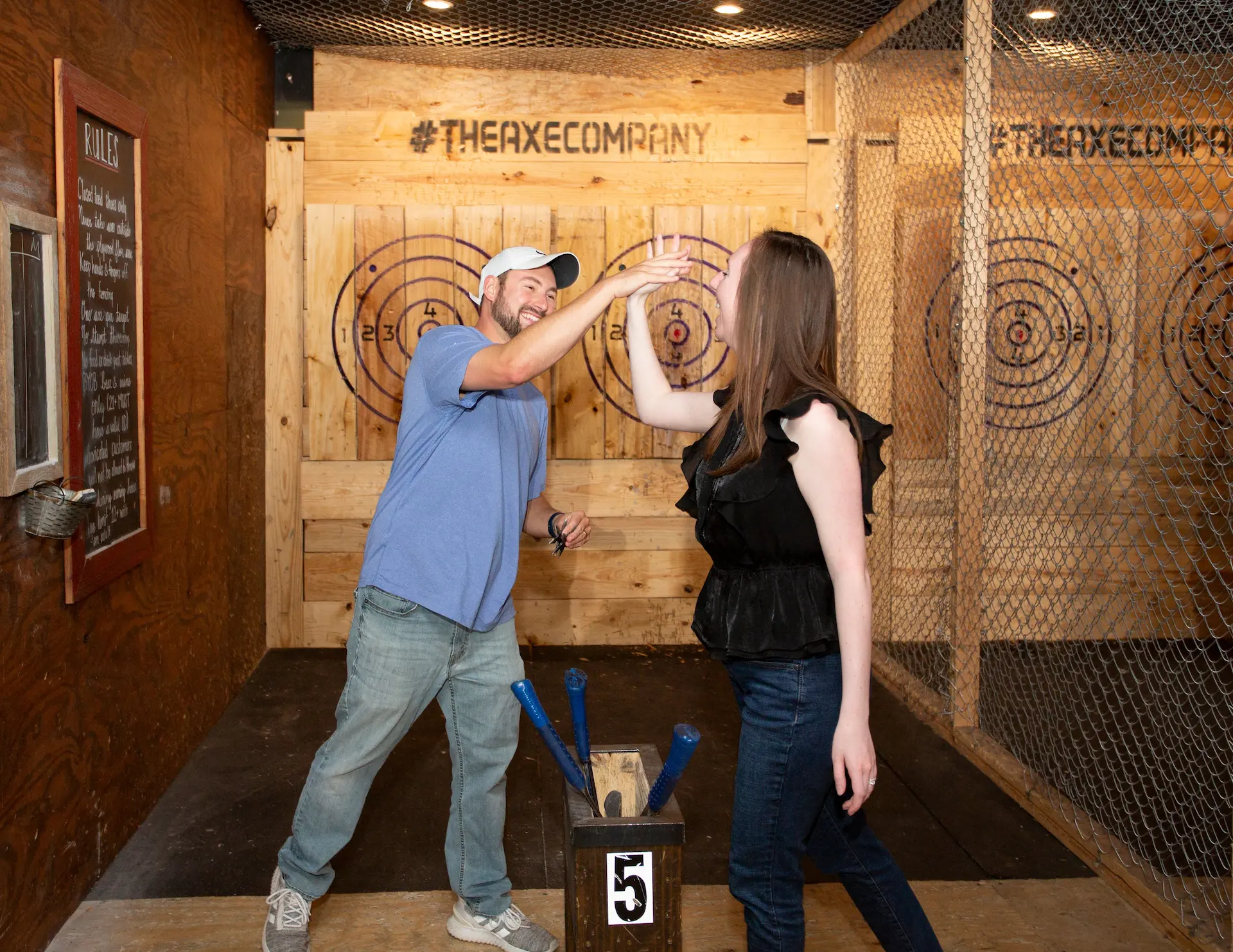 couple high fiving after throwing their axes